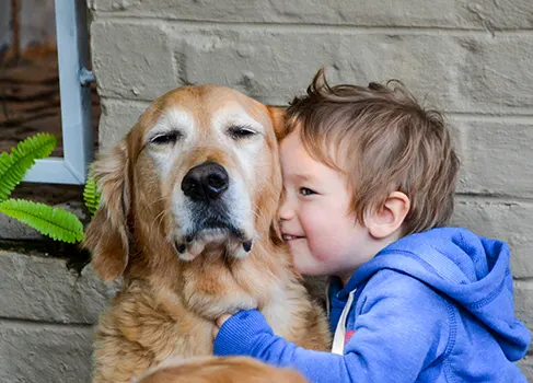 Kind nimmt den Hund in den Arm