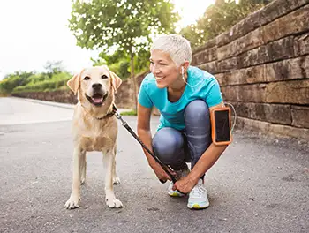 Frau bereitet sich auf die Joggingrunde mit ihrem Hund vor