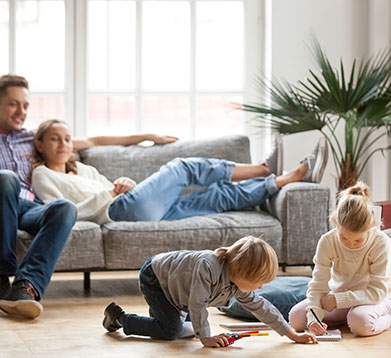 Die preisgekrönten Versicherungen der Ammerländer in der Übersicht Familie im Wohnzimmer