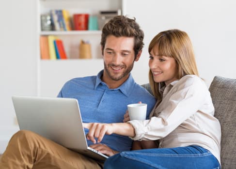 Versicherungsmakler Pärchen sind mit dem laptop auf der Couch