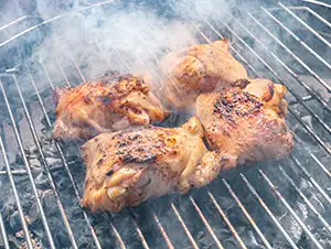 beim Grillen von Fleisch entwickelt sich Rauch
