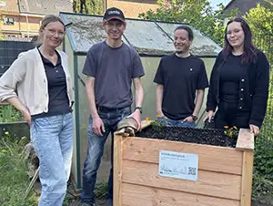 Mia-Sophie, Daniel, Wladimir und Sonja hinter dem neuen Hochbeet für Wildkräuter