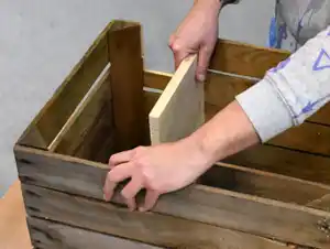 Trennwand einsetzen Trennwand wird in die Holzkiste eingesetzt