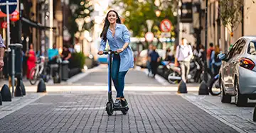 Frau mit ihrem E-Scooter in der Innenstadt