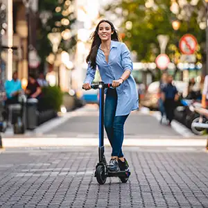 Junge Frau mit ihrem E-Scooter in der Innenstadt