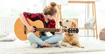 Hund lauscht dem Gitarrenspiel