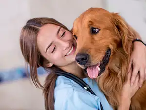 Hund wird von fröhlicher Tierärztin umarmt