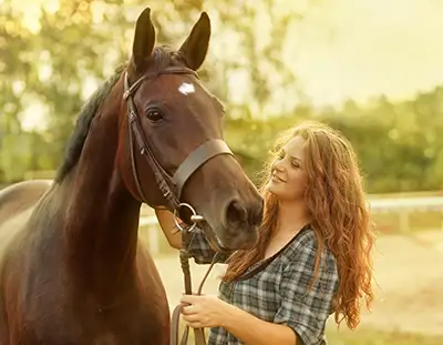 Junge Frau streichelt ihr Pferd